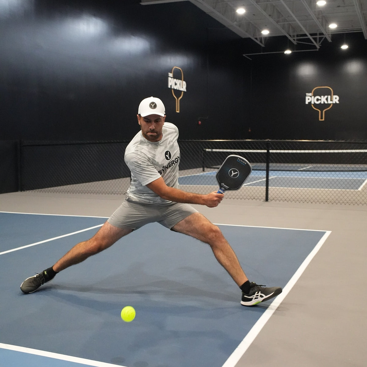 Real Synergy player in action on an indoor pickleball court