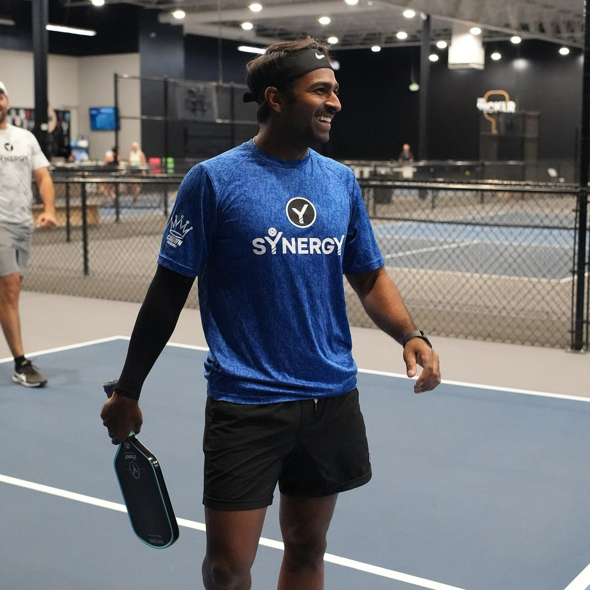Real Synergy player smiling on an indoor pickleball court