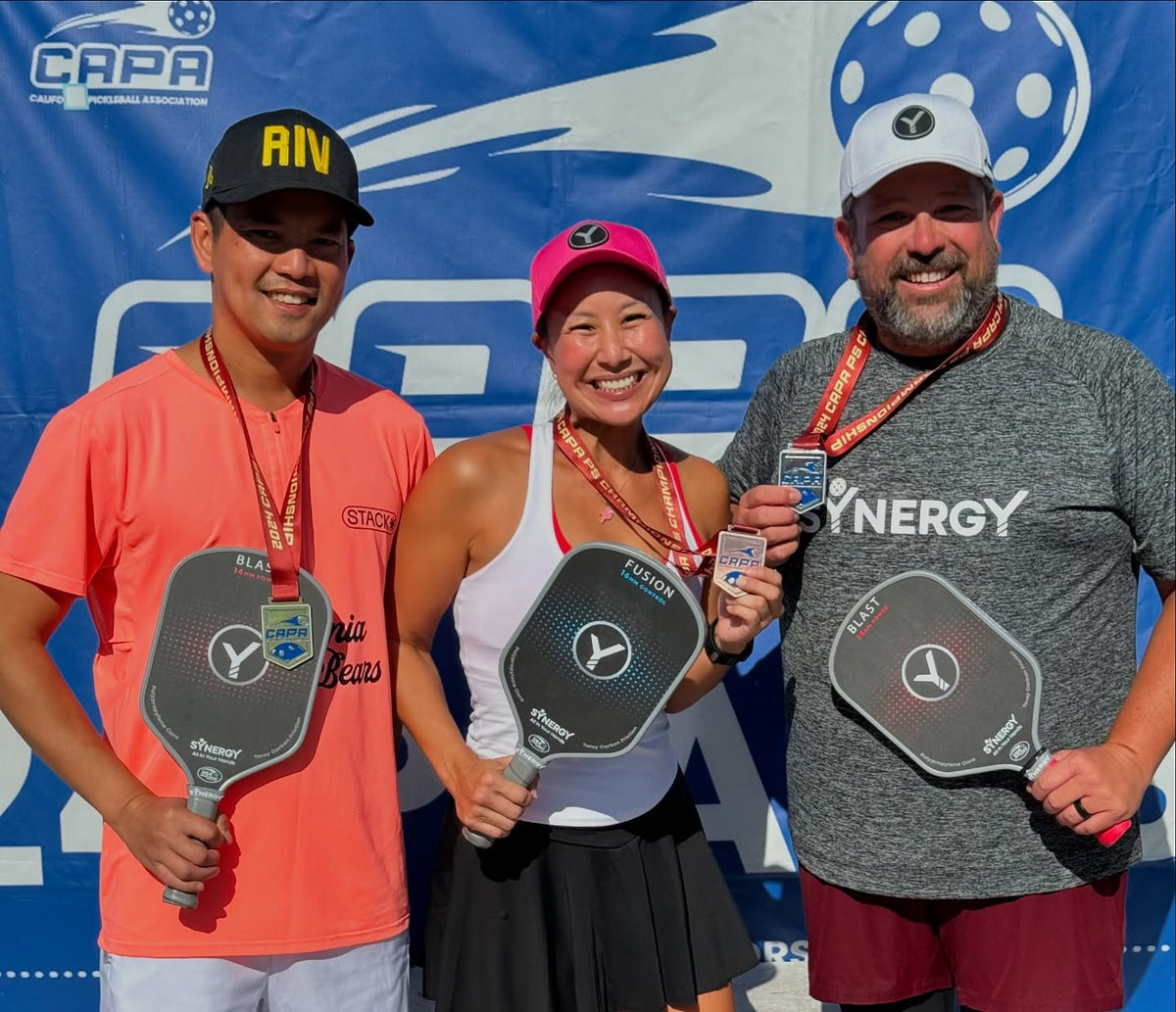 Real pickleball players celebrating together with Synergy paddles and medals