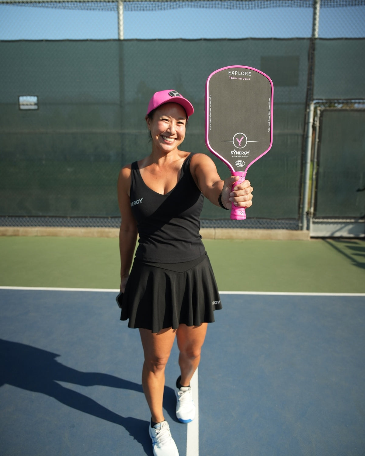Real player holding a pink Synergy Explore paddle