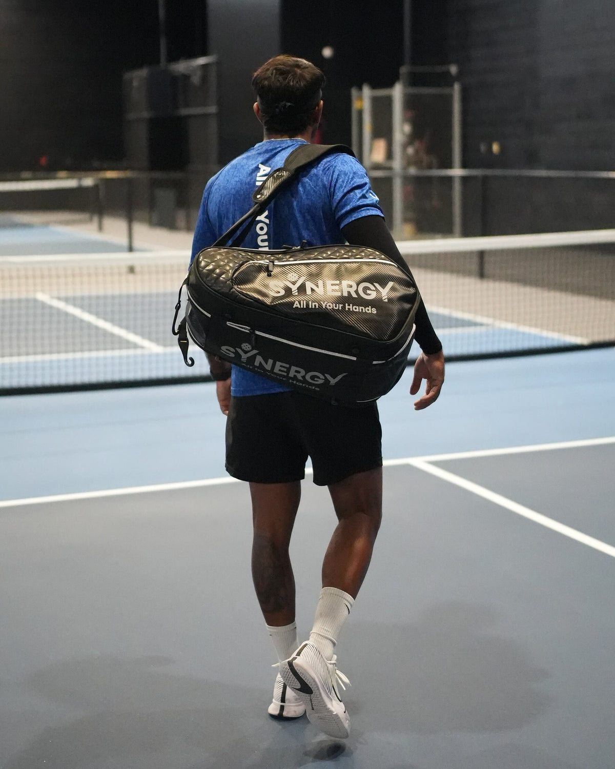 Real player carrying a Synergy pickleball bag on court