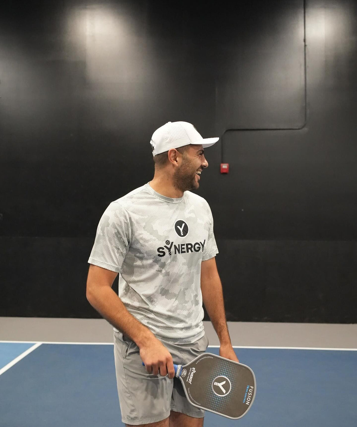 Real Synergy player between points on an indoor court