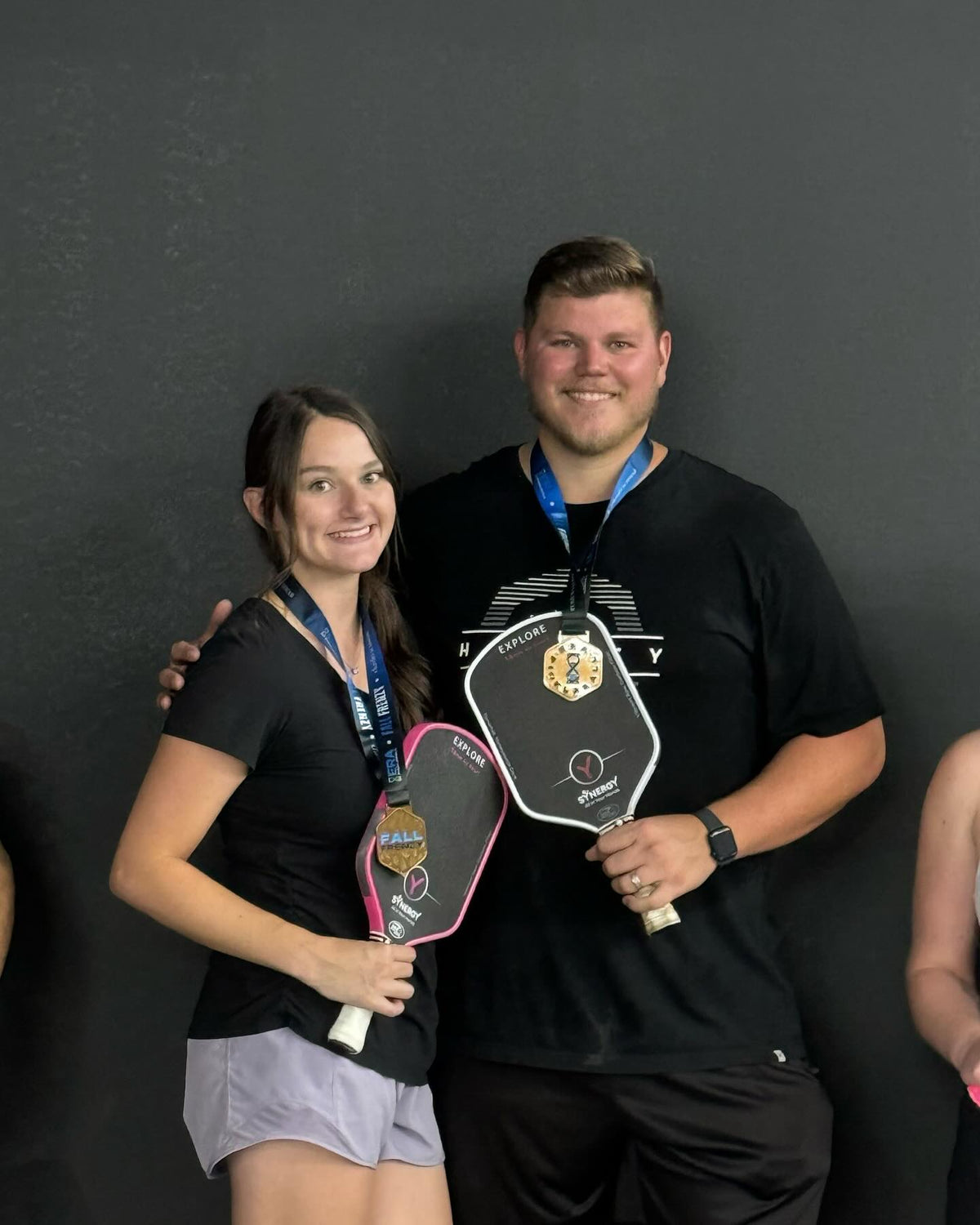 Real pickleball players celebrating with medals and Synergy paddles